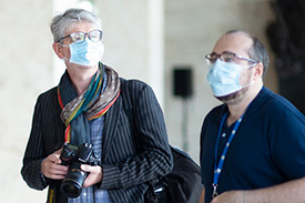 Two journalists wearing masks.