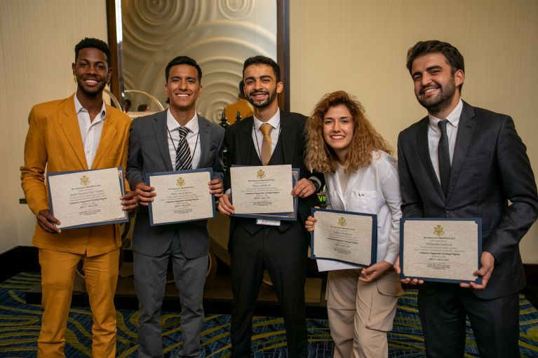 Group of people standing and smiling, holding certificates