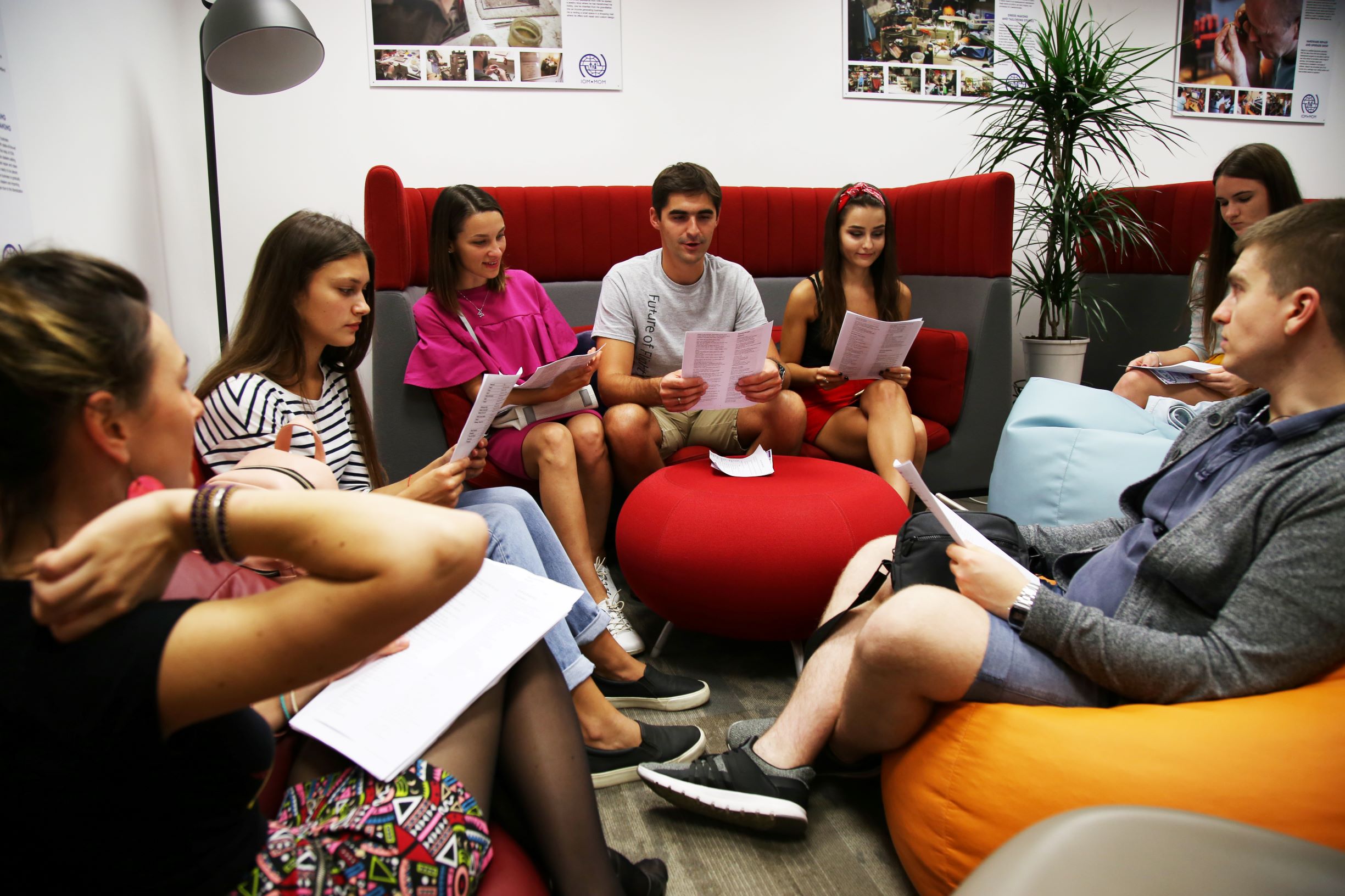 Photo of youth sitting on bean bags reading some papers in a discussion group