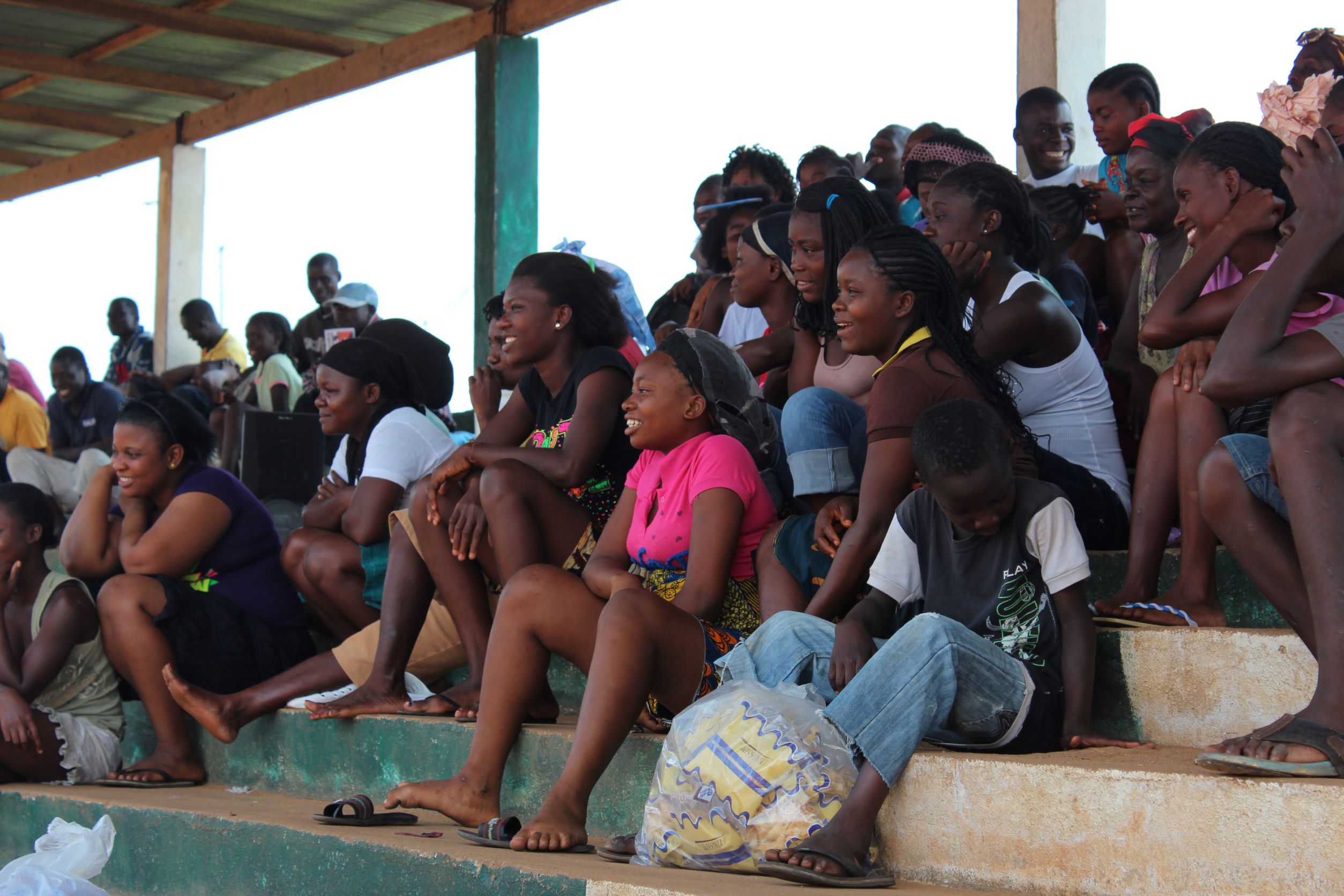 Photo of youth sitting on concrete bleachers at a rally 