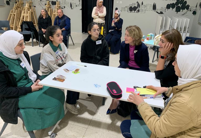 President and CEO Kristin Lord sits with participants at a table