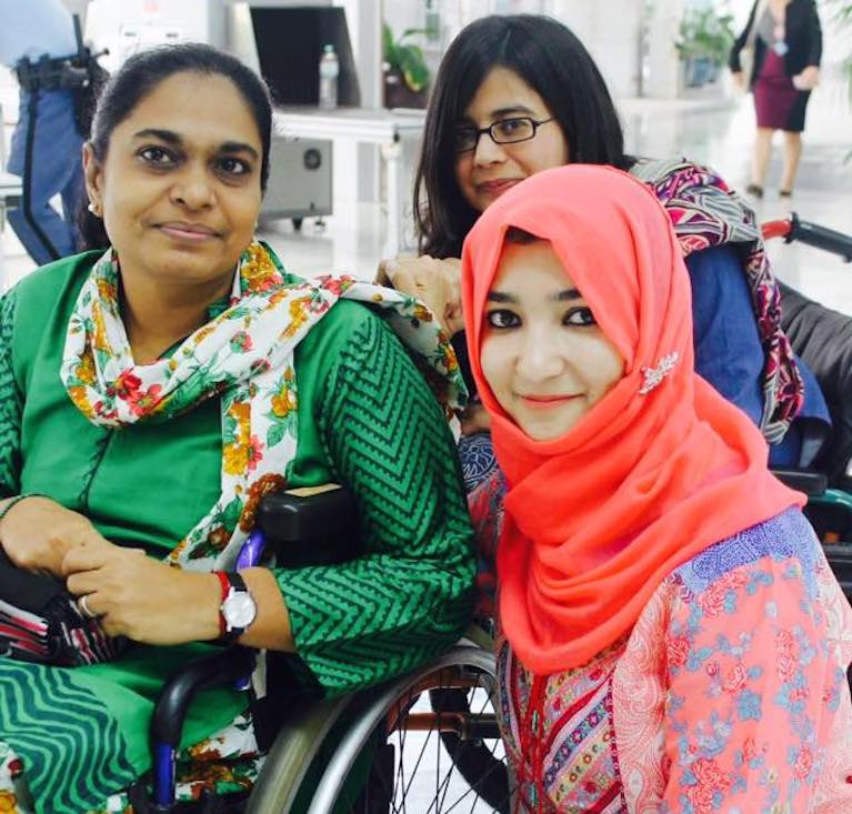 Sumaira is pictured with two woman, one in a wheelchair