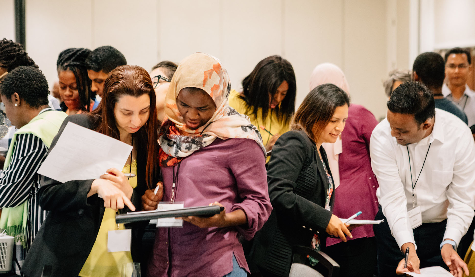 Photo of young leaders looking at documents and discussing ideas during a workshop.