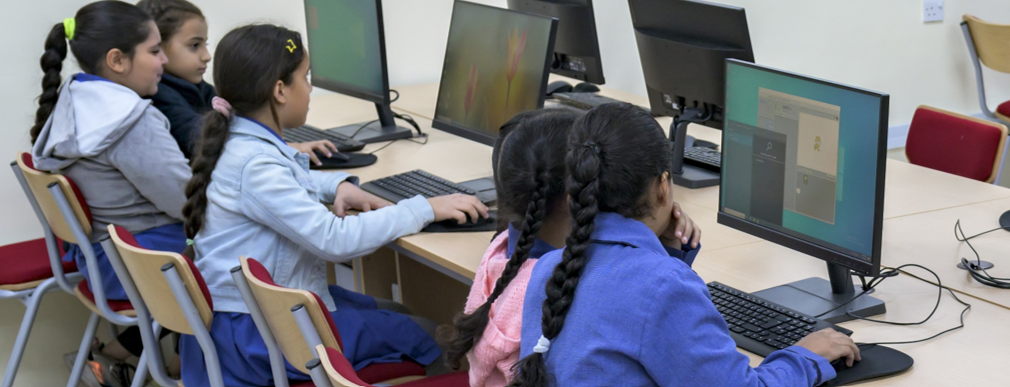 group of young students using computers in computer lab