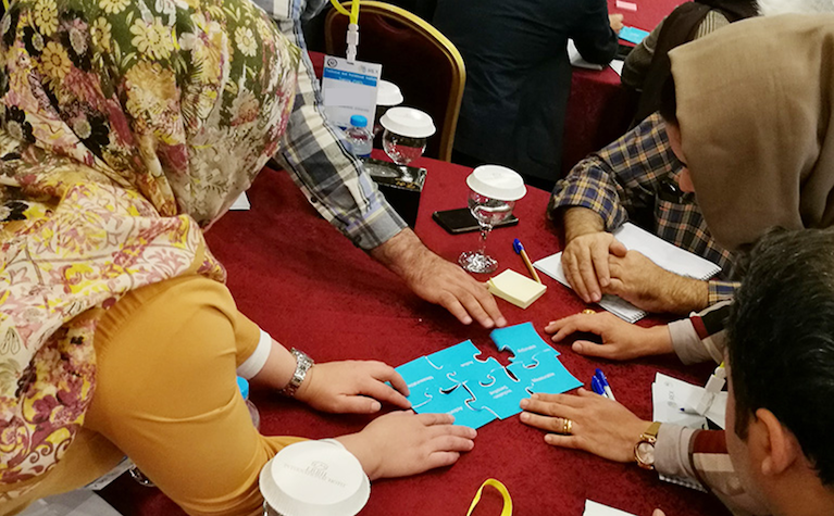 A group of people work on a puzzle