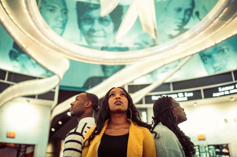 Three participants standing in a circle looking up