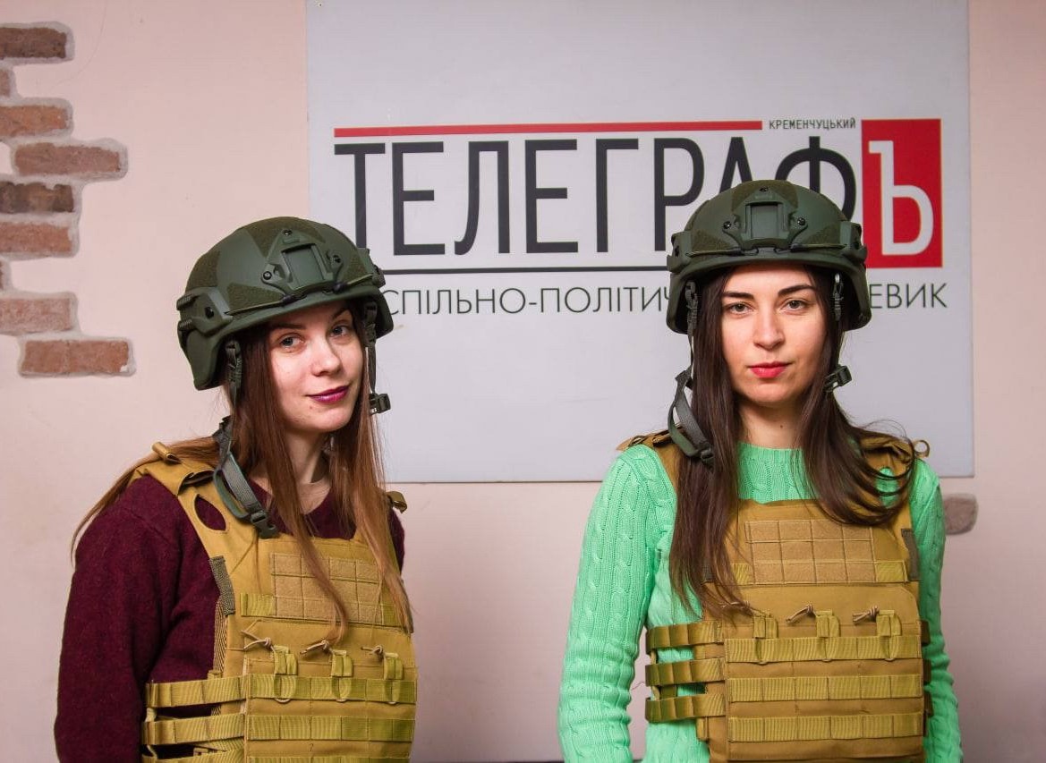 Photo of two female journalists in Ukraine wearing helmets and protective vests