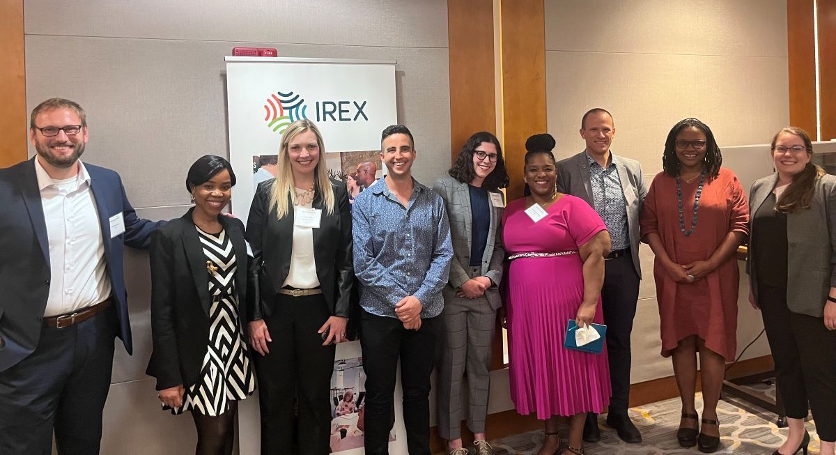 A group of people at a conference standing and smiling