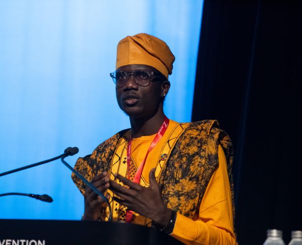 A person standing at a podium with microphones
