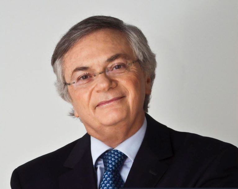 Headshot of Moises, man with glasses and suit smiling 