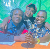 Photo of three youth leaders at a radio station posing in front of a microphone.