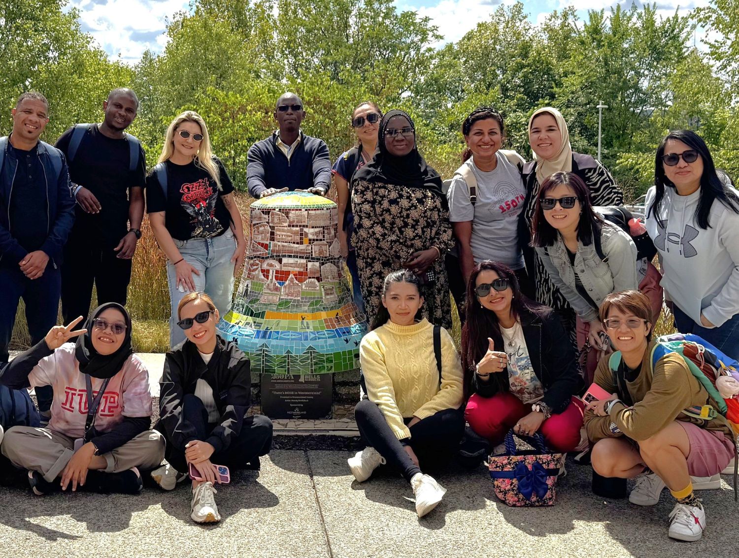 A group of teachers in front of a bell