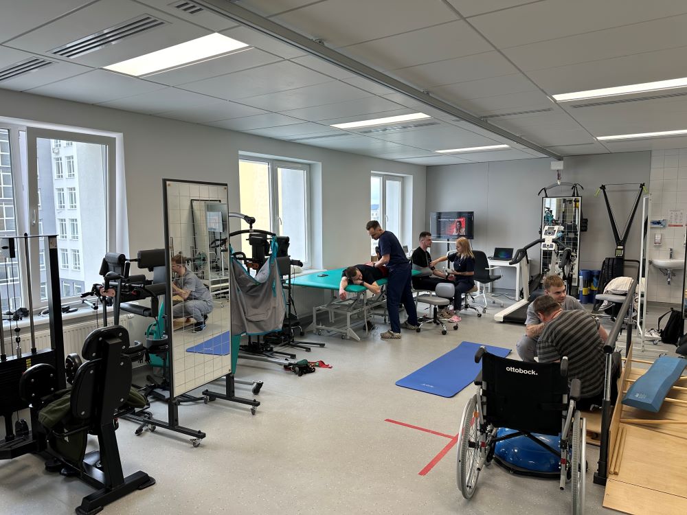 Photo of civilians in a rehabilitation center, some patients are in beds, others in wheel chairs.