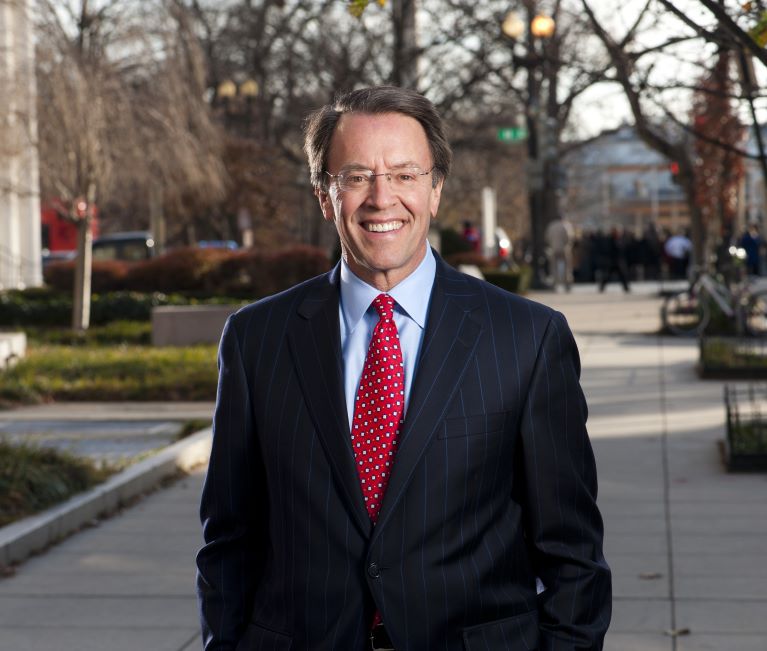 Headshot of Mosbacher, man with glasses and suit smiling 