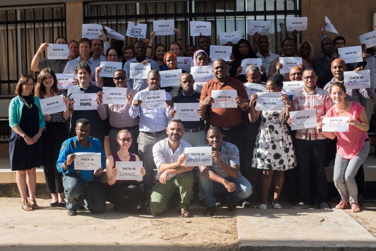 Group photo of people holding a paper that describes their definition of data