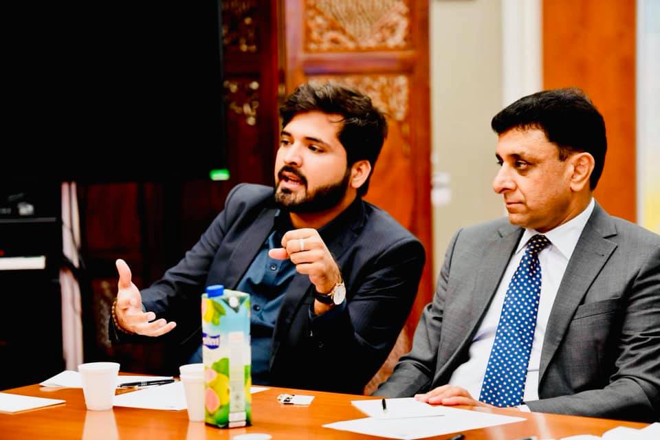 Photo of two men  during a Roundtable Talk. One man is speaking and using his hands to emphasize his point.