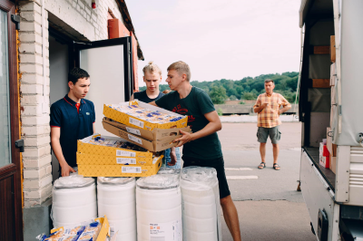 People loading up supplies behind a truck