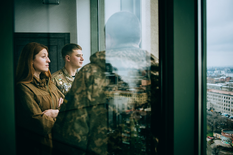 Veterans in military gear standing by window