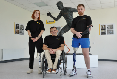 Three veterans with limb loss stand with strength