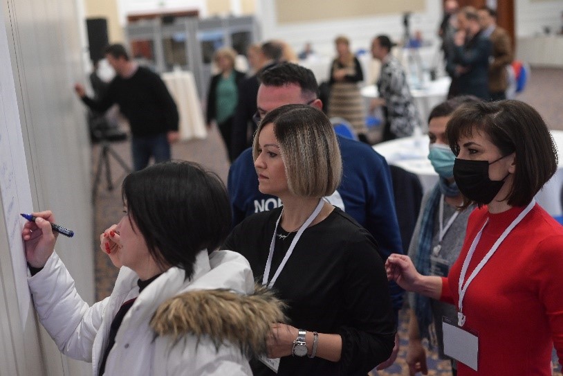 Women stand in line to write on a board at a training event