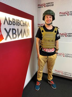 Photo of Yuriy Shivala wearing a protective vest and helmet in the studio.