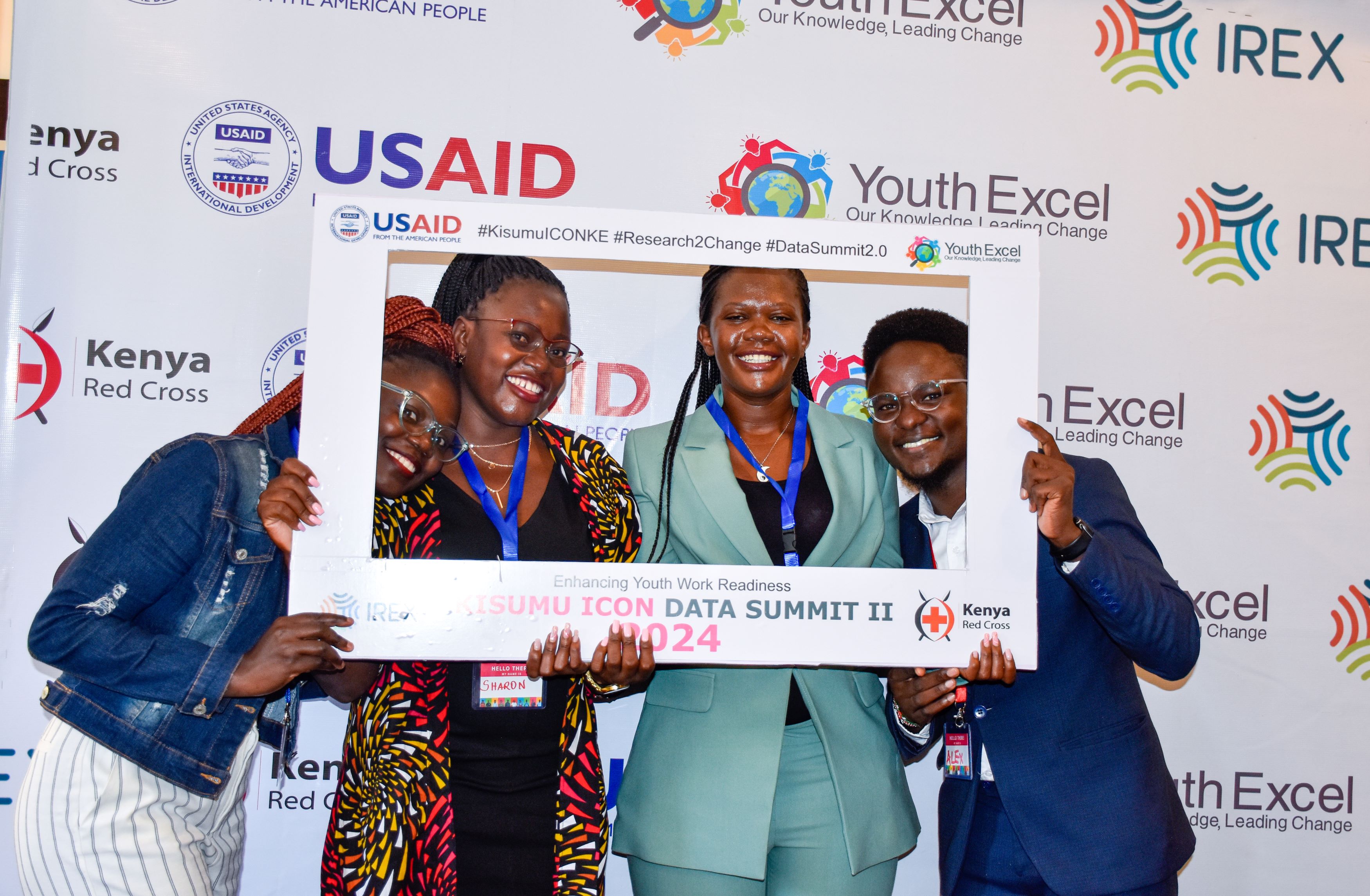 4 youth, male and female, pose in front of a frame during the youth Data summit in Kenya 