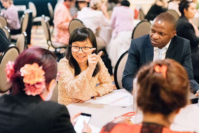 Four people talking at a conference table during an exchange.