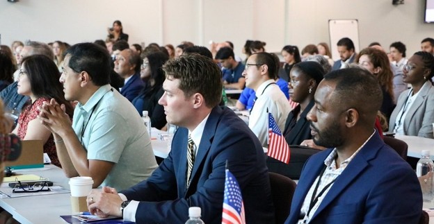 Group of U.S. exchange alumni attentively listening in a session.