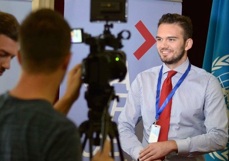 Emir Hasanovikj talking to two people with a video camera