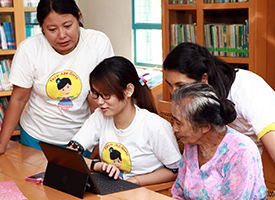 Four women using a tablet in Myanmar