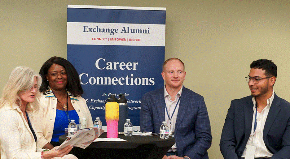 Photograph of four professionals seated around a table at a networking event