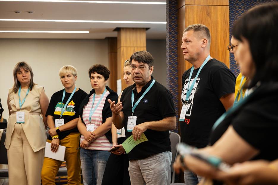 A group of conference attendees gathered indoors during a discussion