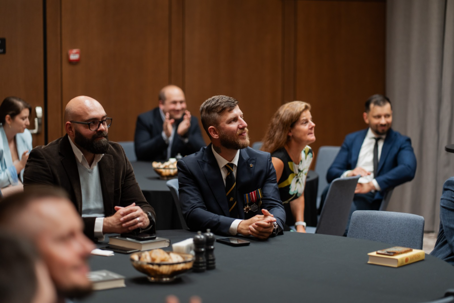 Veterans participants sit at table during graduation ceremony