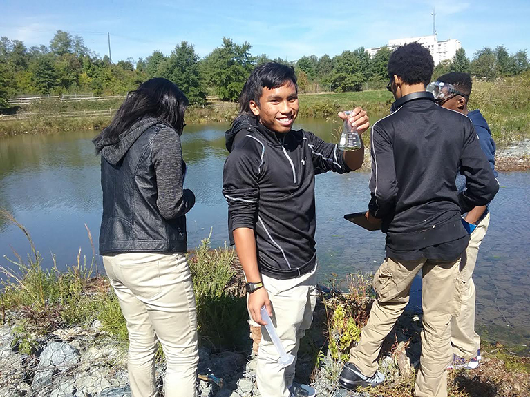 Students collecting lab samples from a river