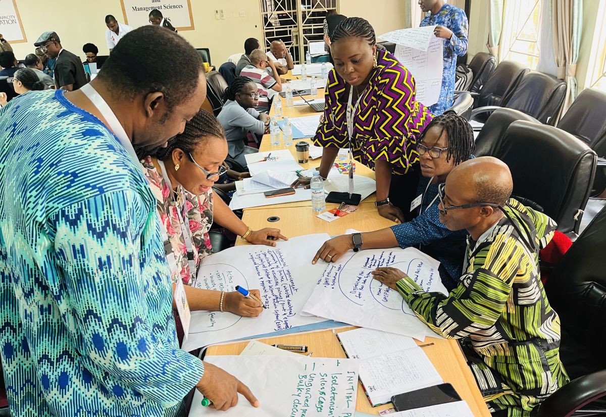People gathered around a table writing on paper