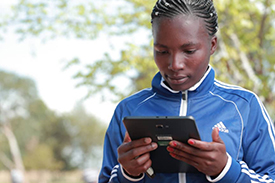 A person using a tablet while standing outside in Tanzania.