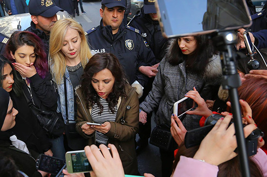 Reporters and residents record a spokesperson with their phones.