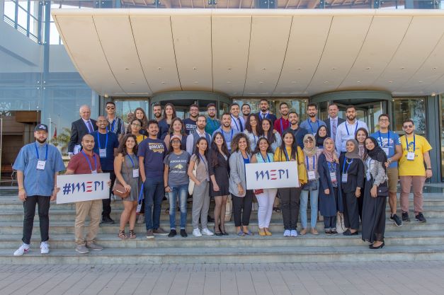 Group of MEPI particpants smiling and holding a MEPI sign