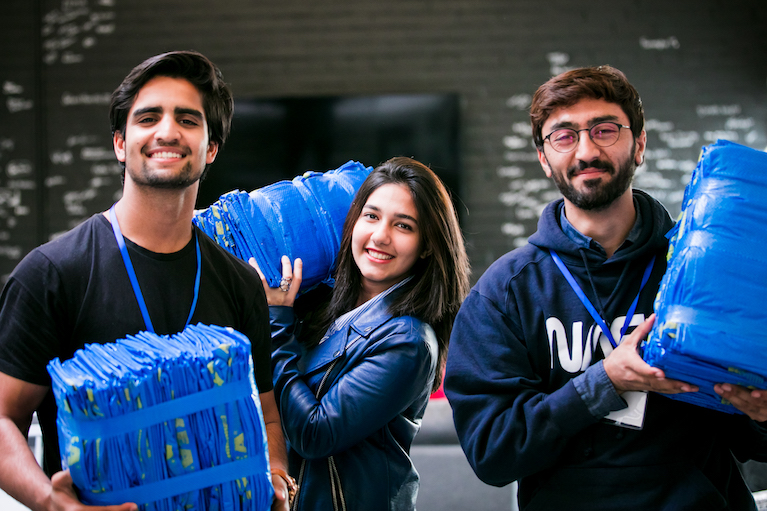 Three participants holding supplies while volunteering.