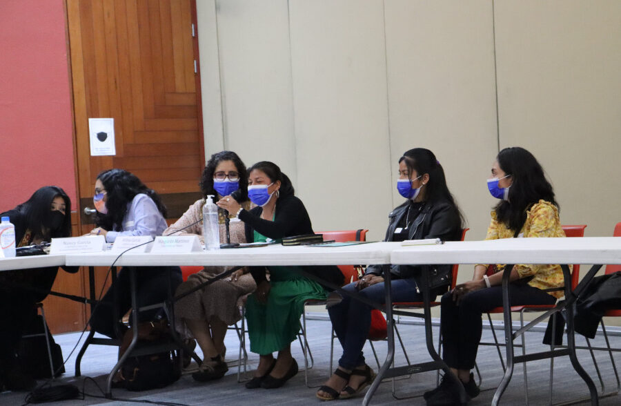 Photo of participants wearing masks, seated at tables during a roundtable discussion