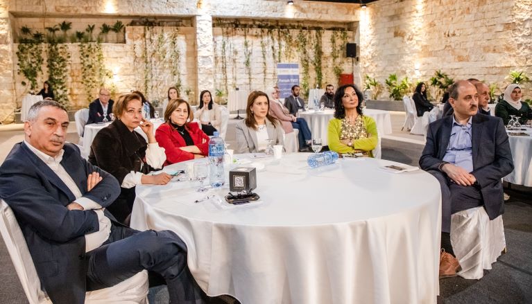 Two men and four women sit together at a table at the launch