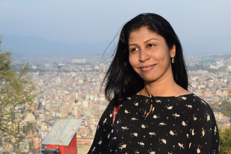 Nirasha Piyawadani on a hilltop overlooking a city.