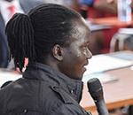 Photo of a young person speaking to an audience in an auditorium during a youth-led labor market assessment.