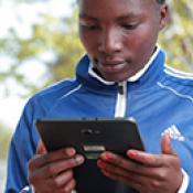 A person using a tablet while standing outside in Tanzania.