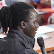 Photo of a young person speaking to an audience in an auditorium during a youth-led labor market assessment.